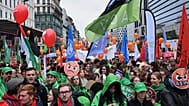 People march with signs crossed out with the number 67, referring to pension age, during a demonstration and general strike in Brussels, Tuesday, Oct. 14, 2025