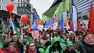 People march with signs crossed out with the number 67, referring to pension age, during a demonstration and general strike in Brussels, Tuesday, Oct. 14, 2025