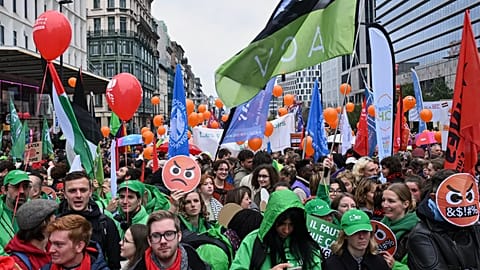 People march with signs crossed out with the number 67, referring to pension age, during a demonstration and general strike in Brussels, Tuesday, Oct. 14, 2025