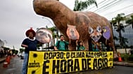 Indígenas posan junto a una gran representación de un capibara