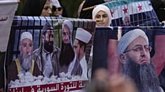 نساء مسلمات سُنّيات يحملن صور الداعية السلفي السني المسجون أحمد الأسير (يمينًا) وعدد من رجال الدين المعتقلين الآخرين