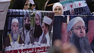 نساء مسلمات سُنّيات يحملن صور الداعية السلفي السني المسجون أحمد الأسير (يمينًا) وعدد من رجال الدين المعتقلين الآخرين