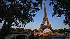 Des passants empruntent le pont d'Iéna menant à la tour Eiffel à Paris, le jeudi 1er juin 2023