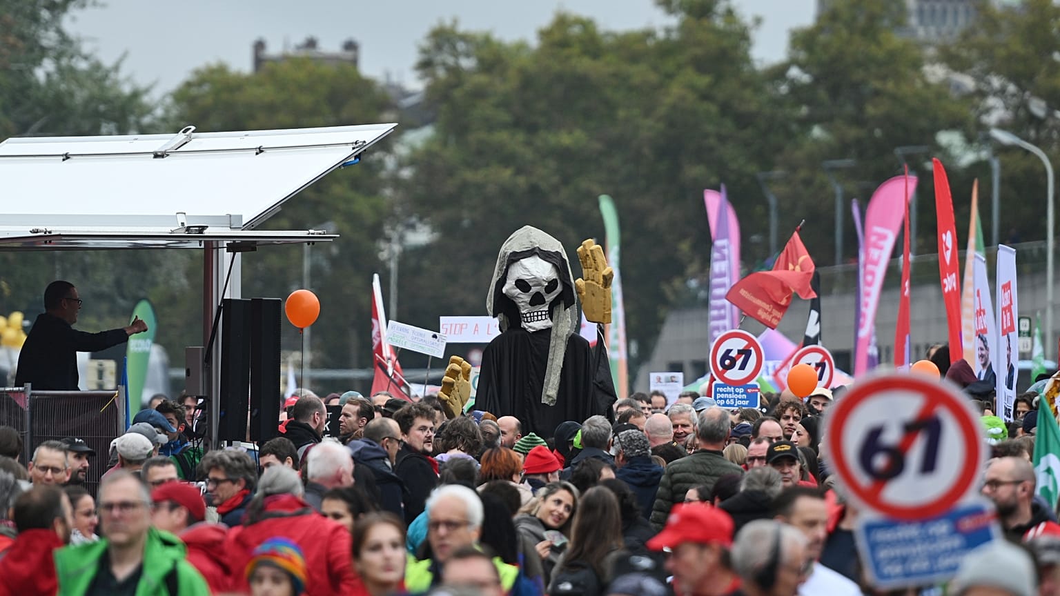 Protestors march with a skeleton and banners
