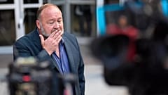 Alex Jones pauses before speaking to the media after arriving at the federal courthouse for a hearing in Houston, 14 June, 2024