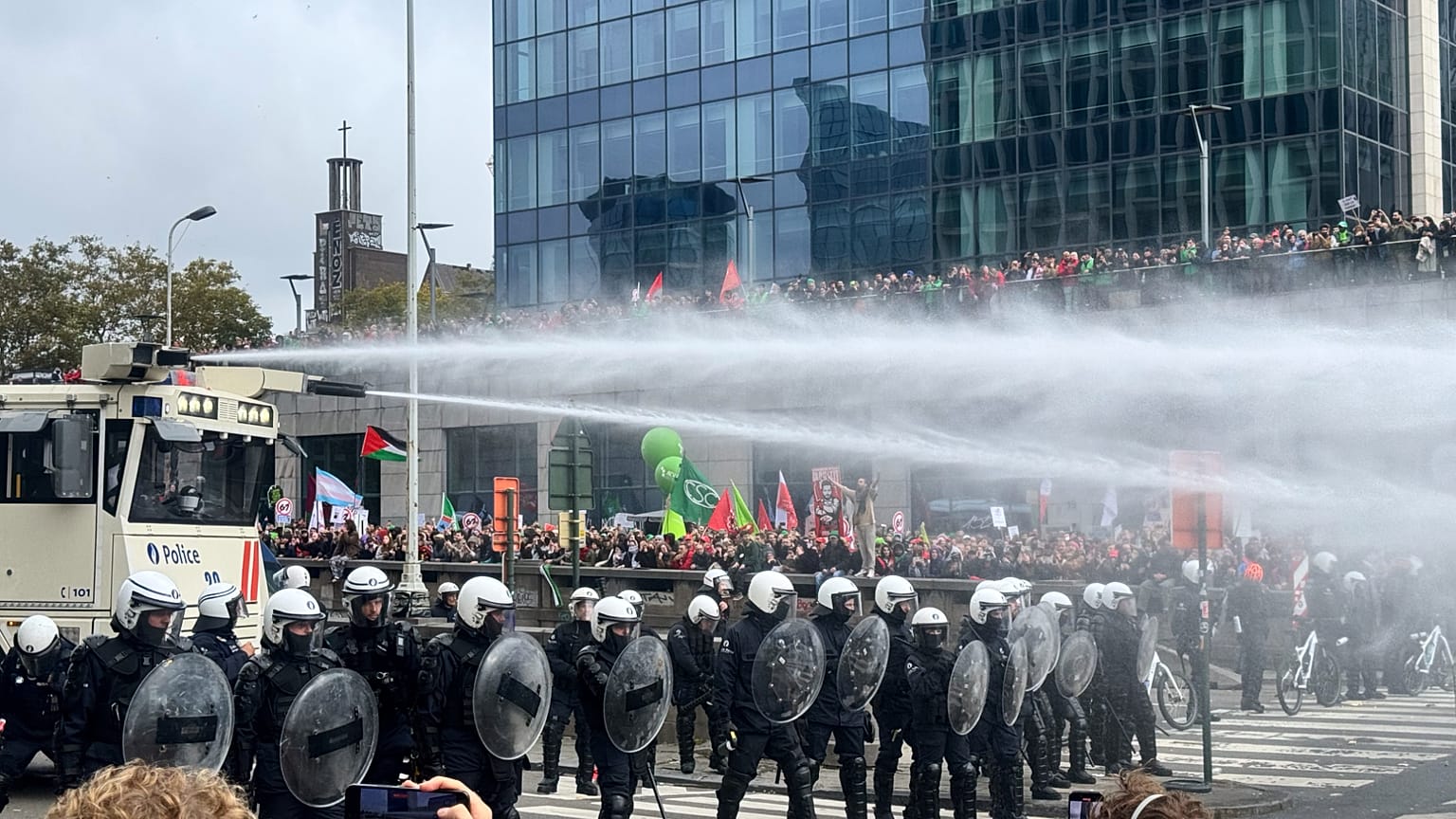 La policía utiliza un cañón de agua contra los manifestantes durante una protesta y huelga general en Bruselas