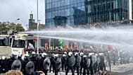 Police use a water cannon against protestors during a demonstration and general strike in Brussels