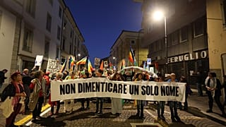 Uczestnicy protestu pro-palestyńskiego trzymają transparent z napisem po włosku: 'Nie zapomnij ani jednego imienia'