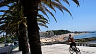 Un homme fait du vélo sur la plage d'Oeiras, dans la banlieue de Lisbonne, le mercredi 19 juillet 2023. 