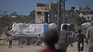 Varios palestinos corren hacia los camiones que transportan ayuda del Programa Mundial de Alimentos en Deir Al Balah, en el centro de Gaza, el miércoles 15 de octubre