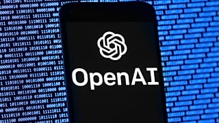 The OpenAI logo appears on a mobile phone in front of a computer screen with random binary data, Thursday, 9 March 2023, in Boston.