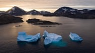 Icebergs float away as the sun rises near Kulusuk, Greenland. 