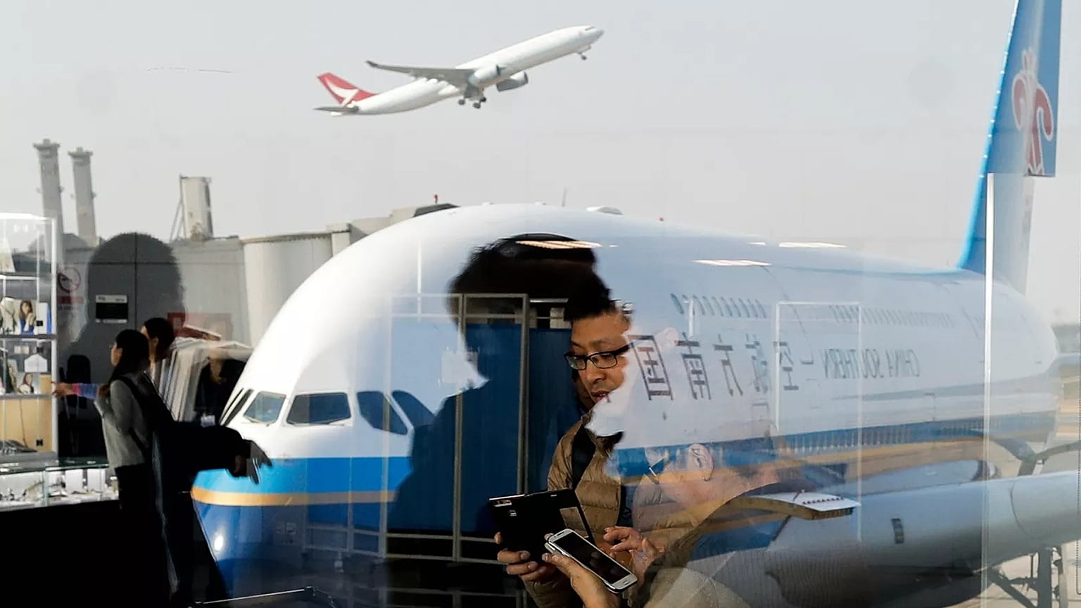 Passengers walk through Beijing Capital International Airport, 19 November, 2016