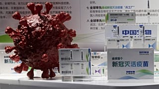 في هذه الصورة الأرشيفية الملتقطة في 6 سبتمبر 2020، تُعرض عينات من لقاح كوفيد-19 الذي أنتجته شركة CNBG التابعة لشركة سينوفارم بالقرب من نموذج ثلاثي الأبعاد لفيروس كورونا