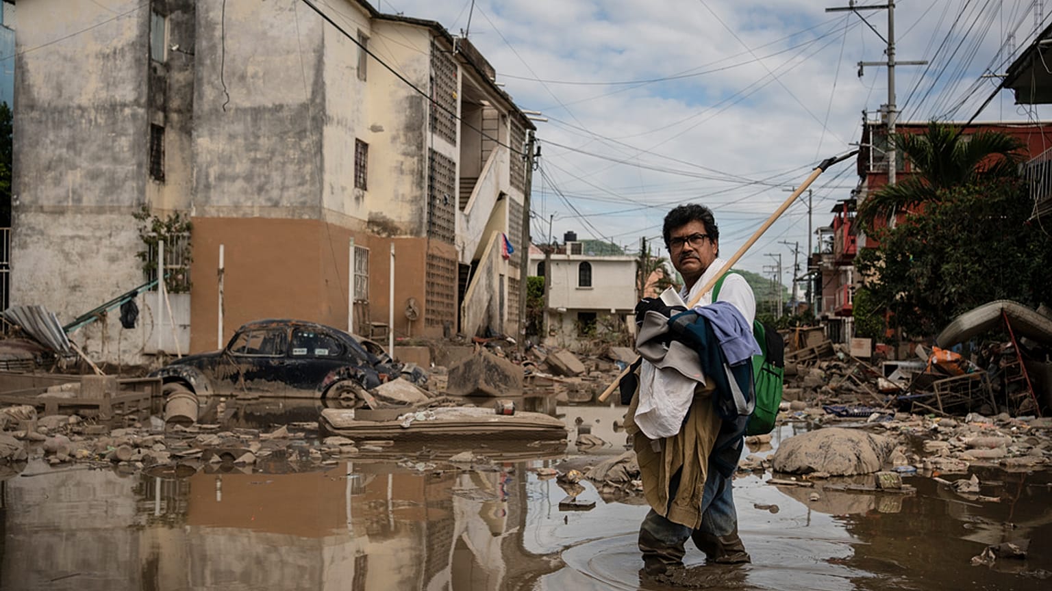Egy férfi átkel egy sáros utcán Poza Ricában, Veracruz államban, Mexikóban, 2025. október 15-én, szerdán, a halálos áradások és a heves esőzések után. 