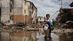 Egy férfi átkel egy sáros utcán Poza Ricában, Veracruz államban, Mexikóban, 2025. október 15-én, szerdán, a halálos áradások és a heves esőzések után. 