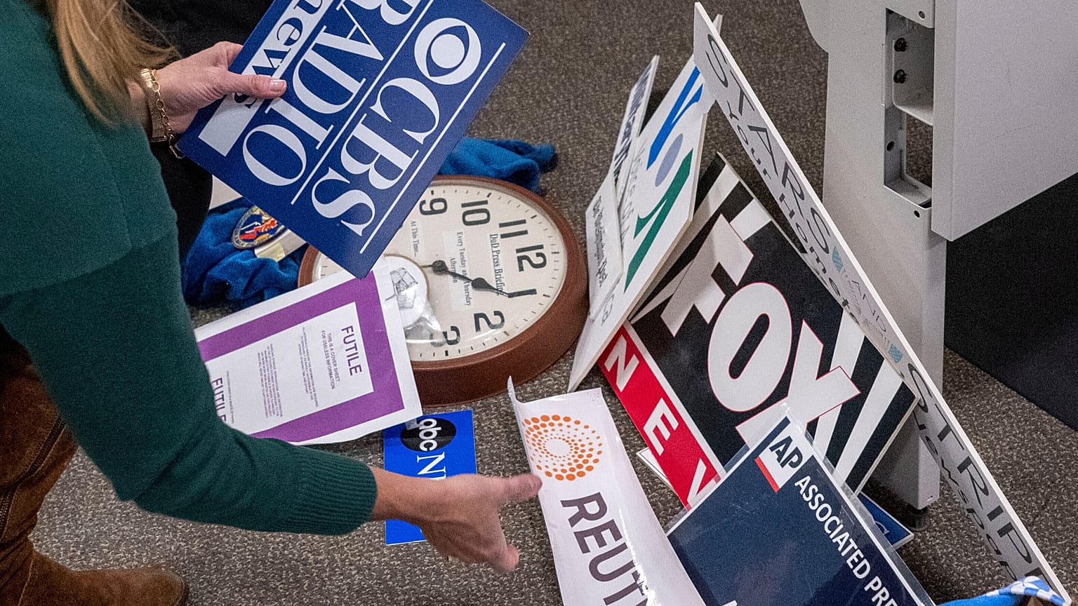 A reporter saves the name plaques from various news outlets as she and members of the media pack up their belongings in the press area in the Pentagon, 15 October 2025