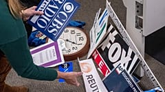 A reporter saves the name plaques from various news outlets as she and members of the media pack up their belongings in the press area in the Pentagon, 15 October 2025