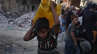 فلسطينيون يحملون عبوات مياه بعد جمعها من شاحنة في مدينة غزة، الخميس 16 أكتوبر/تشرين الأول 2025.