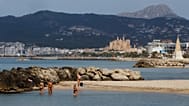 Nesta fotografia de 25 de maio de 2020, as pessoas visitam a praia em Palma de Maiorca, Espanha.