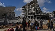 الفلسطينيون يجمعون المياه من أنبوب مكسور وسط المباني المدمرة في مدينة غزة بعد أن اتفقت إسرائيل وحماس على وقف مؤقت للحرب وإطلاق سراح الرهائن المتبقين. (تصوير: أسامة الشريف )