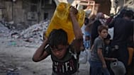 یک کودو فلسطینی در حال حمل سطل آب در در شهر غزه، ۱۶ اکتبر ۲۰۲۵