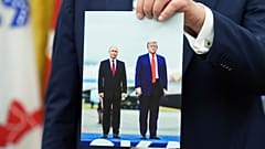 عکس دیدار دونالد ترامپ و ولادیمیر پوتین در دست رئیس‌جمهوری آمریکا