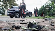 Parts of a car are seen on the ground as Carabinieri military police stand outside the home of investigative journalist Sigfrido Ranucci in Pomezia, 17 October, 2025