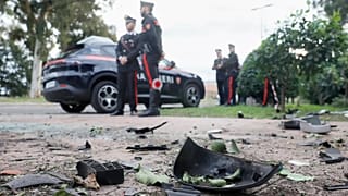 Parts of a car are seen on the ground as Carabinieri military police stand outside the home of investigative journalist Sigfrido Ranucci in Pomezia, 17 October, 2025