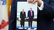 US President Donald Trump holds a photo of himself with Russian President Vladimir Putin during an announcement in the Oval Office, 22 August, 2025