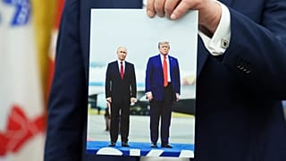 US President Donald Trump holds a photo of himself with Russian President Vladimir Putin during an announcement in the Oval Office, 22 August, 2025