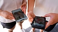 İki genç, 8 Kasım 2024'te Sydney'de sosyal medyayı görüntülemek için telefonlarını kullanıyor.