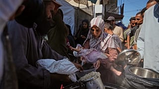  فلسطينيون يتلقون الطعام المتبرع به في مطبخ مجتمعي في دير البلح، وسط قطاع غزة، الخميس 16 أكتوبر/تشرين الأول 2025.