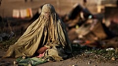 Палестинская женщина стоит рядом с разгромленной мечетью в деревне Бурка на Западном берегу недалеко от Рамаллы, четверг, 10 октября 2013 г.