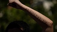 Un manifestante escribe en su brazo: "El racismo mata". Archivo