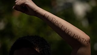 Un manifestante escribe en su brazo: "El racismo mata". Archivo