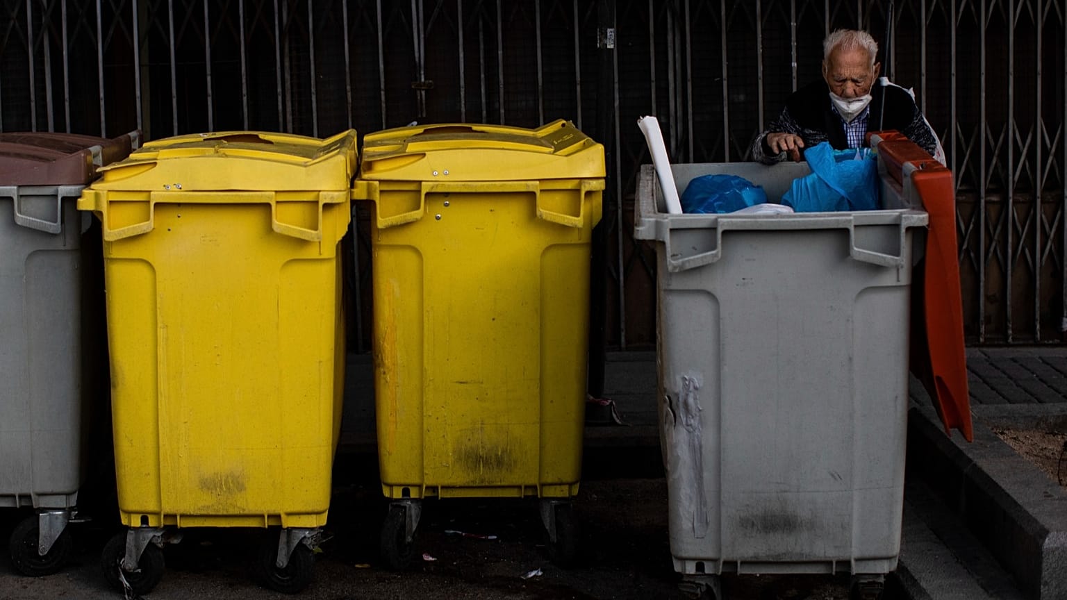 Un anciano busca en los contenedores de basura en el barrio sur de Vallecas, Madrid, España, el jueves 1 de octubre de 2020.