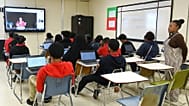 كيتلين بيركنز، معلمة افتراضية (على الشاشة على اليسار)، والمعلمة تامي روكر لمادة الإنجليزية للصف التاسع (على اليمين) خلال الحصة في مدرسة يازو سيتي الثانوية
