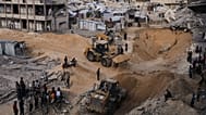 Palestinians watch members of the Hamas militant group searching for bodies of the hostages in an area in Hamad City, Khan Younis, in the southern Gaza Strip, Oct. 18 2025.