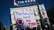 Un manifestant tient une pancarte lors d'une manifestation anti-Trump, à Madrid, Espagne, le samedi 18 octobre 2025.