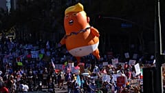 Des manifestants tirant une structure gonflable géante de Donald Trump défilent dans les rues lors d'une manifestation "No Kings", samedi 18 octobre 2025, à Los Angeles.