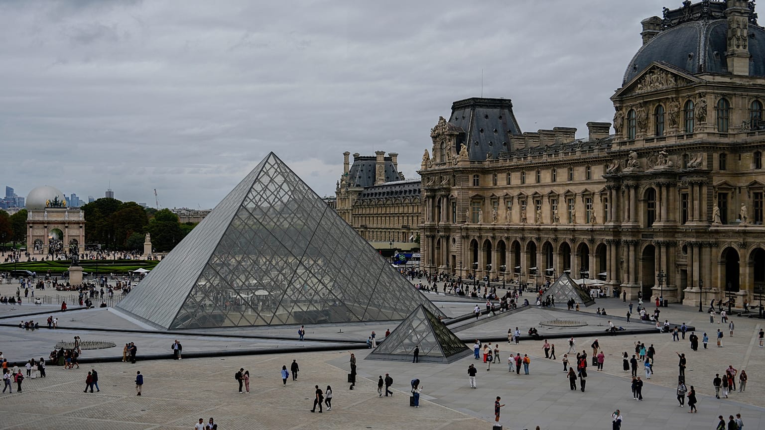File: People walk outside the Louvre museum, Sunday, Aug. 31, 2025, in Paris