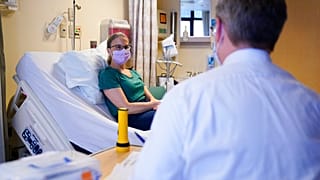 مريضة تتحدث مع طبيبها قبل تلقي جرعتها الثالثة من لقاح تجريبي لسرطان الثدي في المركز الطبي لجامعة واشنطن - مونتليك، الثلاثاء 30 مايو 2023، في سياتل.