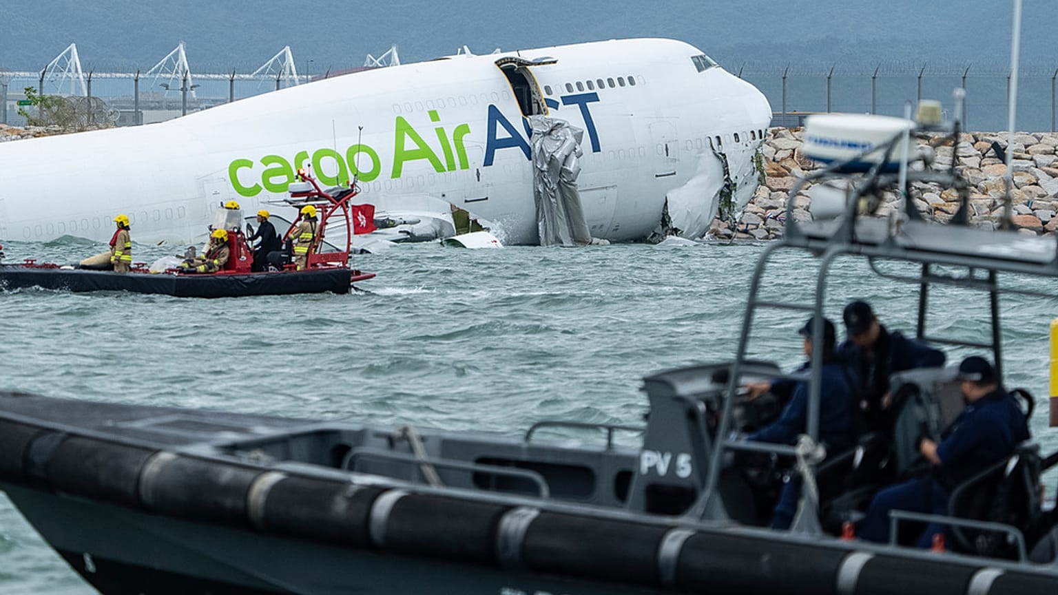 Rescue workers approach a cargo aircraft that skidded off a Hong Kong runway on Monday, Oct. 20, 2025. 