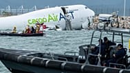 Rescue workers approach a cargo aircraft that skidded off a Hong Kong runway on Monday, Oct. 20, 2025. 