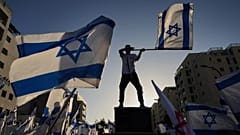 Люди собираются, чтобы поприветствовать освобожденного израильского заложника, когда он возвращается домой из больницы в Мевасерет Цион, 19 октября 2025 г.