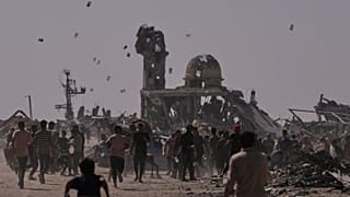 Palestinians collect leaflets dropped by an Israeli drone warning people to stay away from the so-called yellow line in Khan Younis, 20 October, 2025