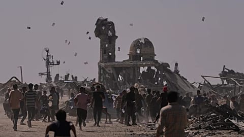 فلسطینیان جزواتی که توسط یک پهپاد اسرائیلی انداخته شده است را جمع آوری می کنند که به مردم هشدار می دهد از خط به اصطلاح زرد دور بمانند در خان یونس، 20 اکتبر 2025