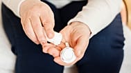 A woman takes a pill.
