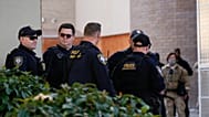 Αξιωματικοί των υπηρεσιών επιβολής του νόμου περιμένουν δίπλα στις πύλες μιας εγκατάστασης της Υπηρεσίας Μετανάστευσης και Τελωνείων των Ηνωμένων Πολιτειών (ICE), ενώ άλλοι αξιωματικοί συνομιλούν με διαδηλωτές στο Πόρτλαντ της Ορεστιάδας, Mond